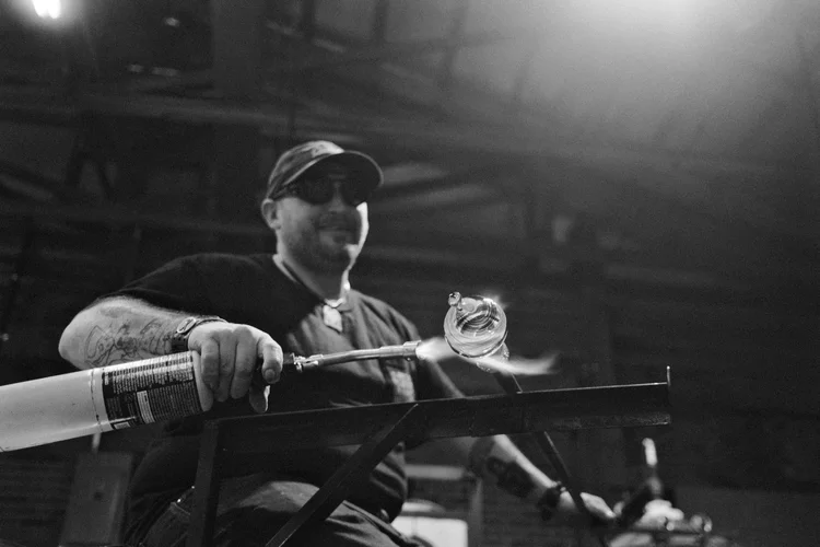 west virginia artist welding a blown glass piece